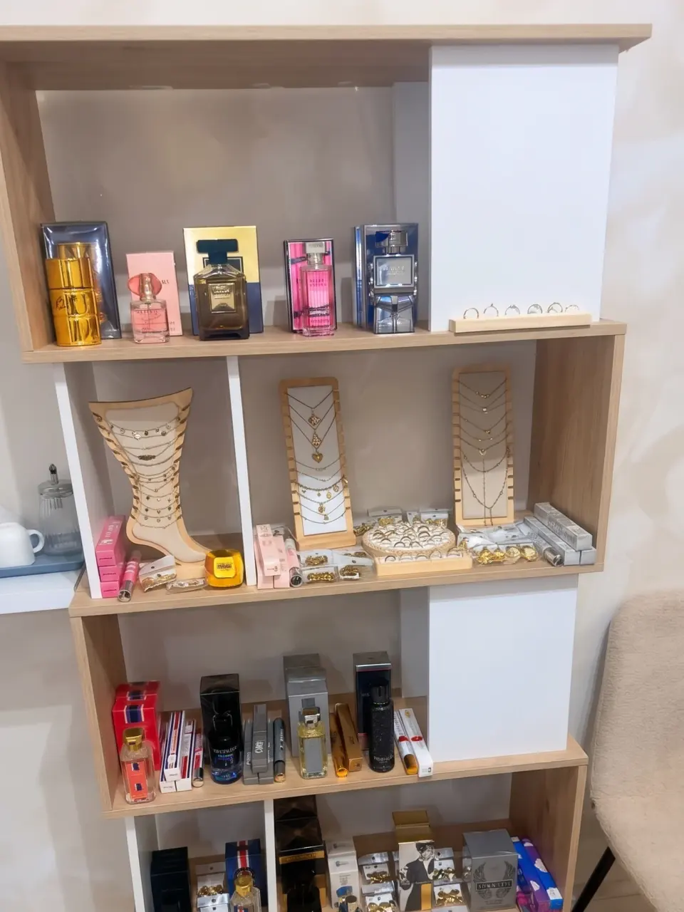 Une étagère de la boutique NEWELA au Marin, garnie de parfums et de bijoux.